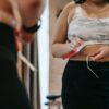 woman measuring waist with tape in gym