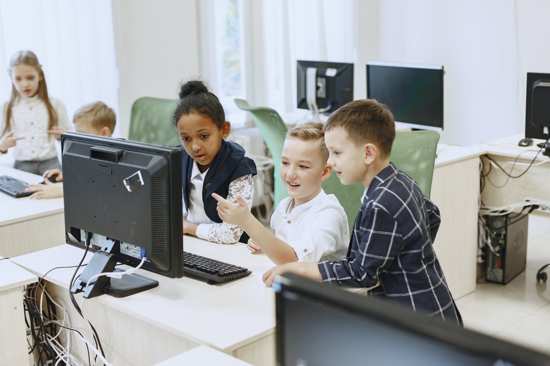 children taking it classes looking at a computer screen